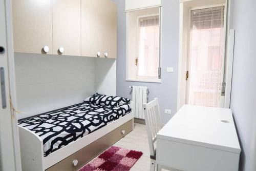 a white room with a bed and a table at Casa Mitch in Catania