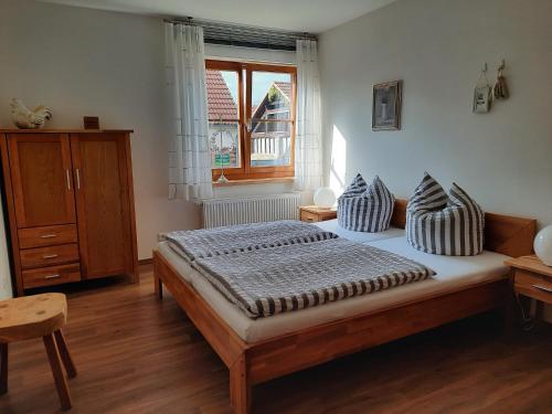 ein Schlafzimmer mit einem Bett mit Kissen und einem Fenster in der Unterkunft Auf "Kleine Wiesen" in Lübbenau