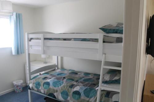 a bedroom with two bunk beds and a bed at 78 Florida Holiday Park in Hemsby
