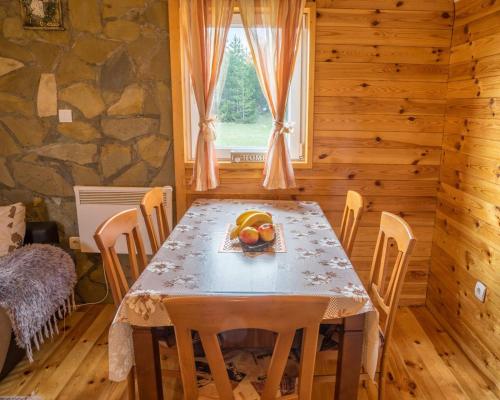 a dining room with a table and chairs and a window at Village Borje in Žabljak