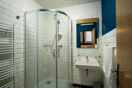 a bathroom with a glass shower and a sink at Penzión Mamut Revúca in Revúca