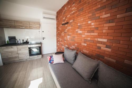 a living room with a brick wall and a couch at Lawendowo- sauna, basen, domki w ogrodzie i apartamenty w kamienicy in Sandomierz