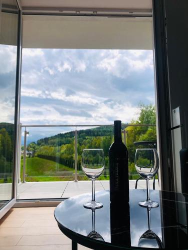 a bottle of wine sitting on a table with two wine glasses at Bliżej nieba in Jelenia Góra