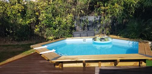 a small pool with a wooden deck and a swimming poolitures at Maison neuve avec jardin au calme in La Crau