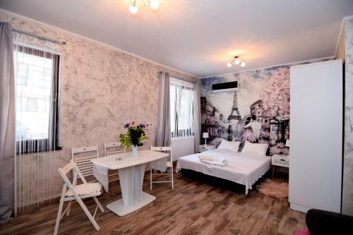 uma sala de estar com uma cama, uma mesa e cadeiras em Ioana Studio Mamaia Nord em Mamaia Nord – Năvodari