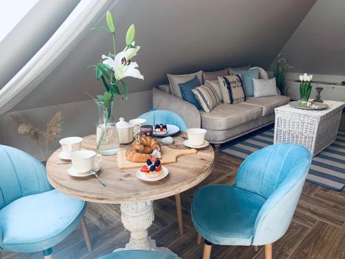 - un salon avec une table et des chaises bleues dans l'établissement Apartamenty Kamienica Arte 5, à Ustka