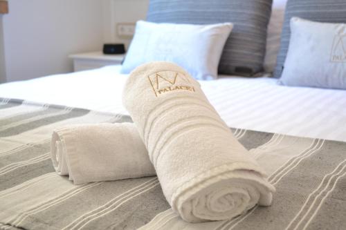 toalla enrollada encima de la cama en Palace M, en Šibenik