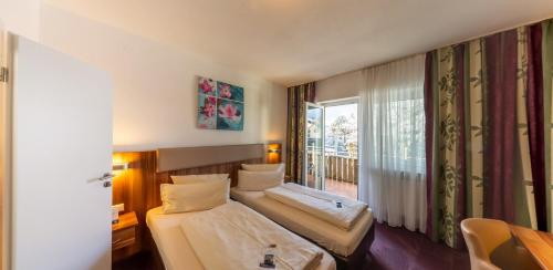 a hotel room with two beds and a window at Hotel Löwen in Meckenbeuren