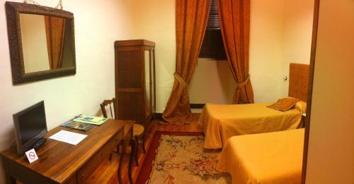 a room with two beds and a desk with a television at ARTE Y NATURA VALDIVIELSO in Quintana de Valdivielso