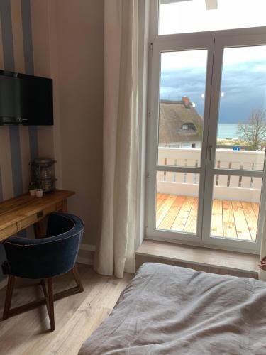 a bedroom with a large window with a view of the ocean at Strandhaus WOTAN in Kühlungsborn