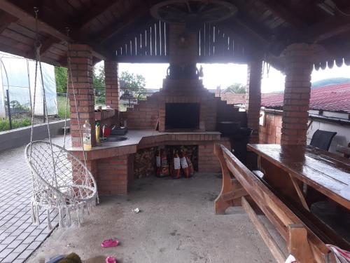 un patio al aire libre con chimenea y banco en Cabana Ema, en Beclean
