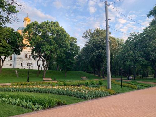 a park with flowers and a building in the background at Аппартаменты в самом центре Площадь-Вал in Chernihiv
