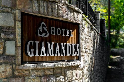 a sign on the side of a brick wall at Hotel Giamandes in Elati Trikalon