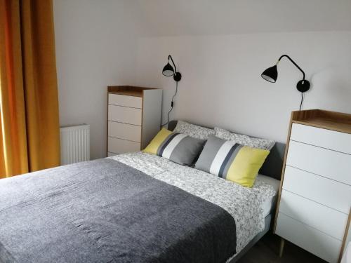 a bedroom with a bed with two lamps on it at apartament good vibes C in Tupadły