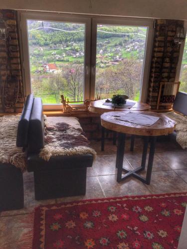 a living room with a table and a couch and a window at Konak Umoljani in Umoljani