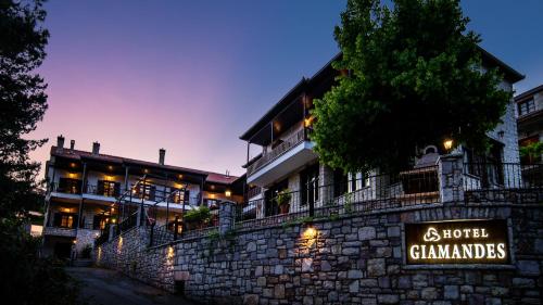 a building with a sign on a stone wall at Hotel Giamandes in Elati Trikalon