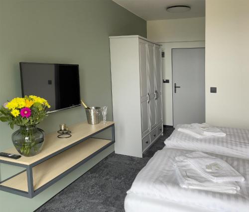 a bedroom with two beds and a vase of flowers at Restaurant & Pension u Hradu in Šternberk