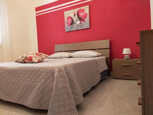 トラーパニにあるCasa Vacanze Leonardoの赤い壁のベッドルーム1室