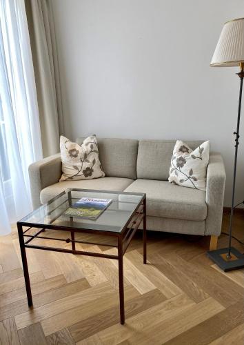 a living room with a couch and a glass coffee table at Boutique Hotel Aichinger in Nussdorf am Attersee
