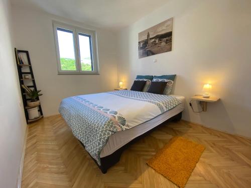 a bedroom with a large bed with two lamps on it at Blue View Apartment in Crikvenica