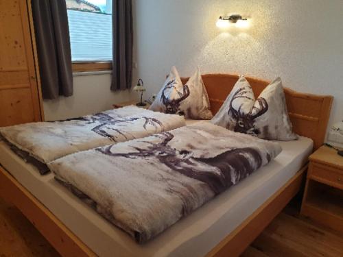 ein Schlafzimmer mit einem Bett mit einer Decke darauf in der Unterkunft Haus Angelika in Ehrwald