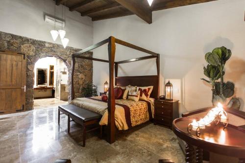 a bedroom with a canopy bed and a table at Casa Legado in Aguascalientes