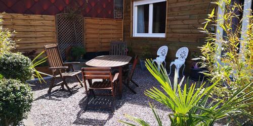 un patio con tavolo e sedie di fronte a una casa di La Cour du Puits, chambre Colyn a Cormeilles