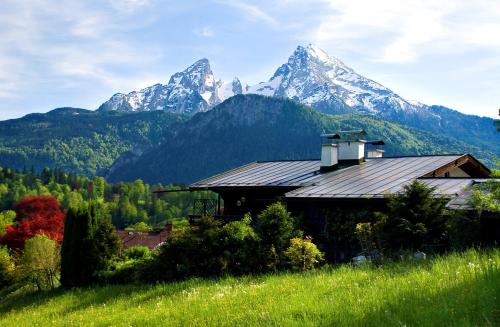 a house on a hill with mountains in the background at Haus Schmidt in Berchtesgaden