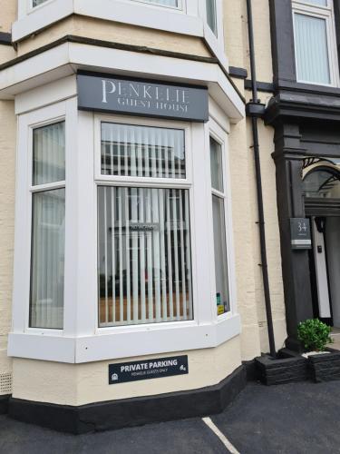 un escaparate con una señal en el lateral de un edificio en The Penkelie en Southport