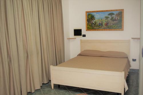 1 dormitorio con 1 cama y una pintura en la pared en Minerva casa vacanze, en Castro di Lecce