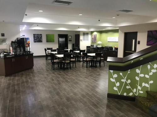 a restaurant with tables and chairs in a room at Sleep Inn Raleigh Durham Airport in Durham