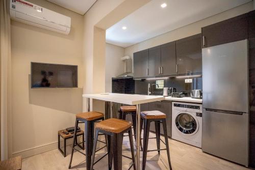 a kitchen with a counter and stools in it at Fani's Seacret in Varkiza