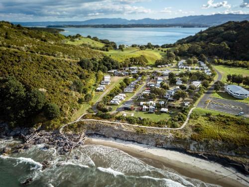 an aerial view of a campgrounds next to the water at Bowentown Beach Holiday Park in Waihi Beach