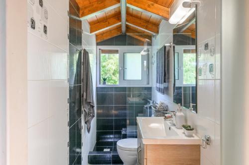 a bathroom with a sink and a toilet at Sunshine House Corfu in Anemómylos