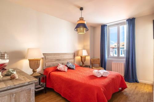 - une chambre avec un lit rouge et une fenêtre dans l'établissement Biarritz Beaurivage, à Biarritz