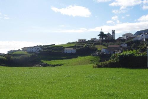 un champ verdoyant avec des maisons au sommet d'une colline dans l'établissement Casa J Dias, à Nordeste