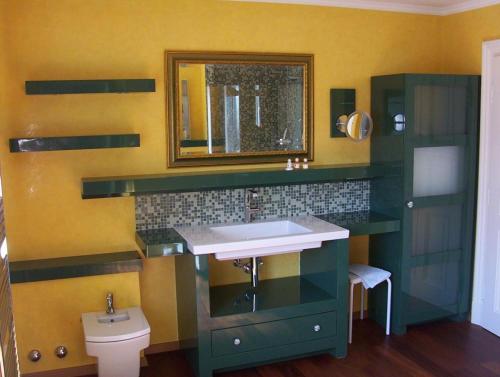 ein Badezimmer mit einem Waschbecken, einem Spiegel und einem WC in der Unterkunft Haus Norden in Grömitz