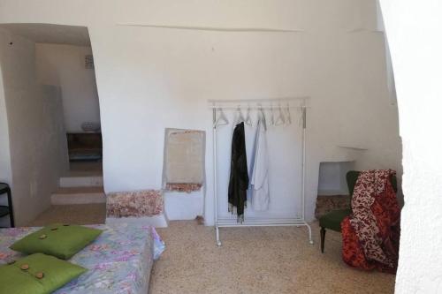 1 dormitorio con cama, armario y silla en Trullo delle More, en Carovigno