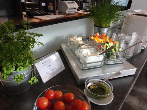 a counter topped with bowls of food and vegetables at Hotel Am Stadtpark in Buxtehude
