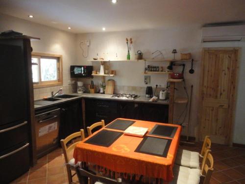 une cuisine avec une table et des chaises dans une cuisine dans l'établissement Villa de plein pied en campagne bonifacienne 84m2., à Bonifacio
