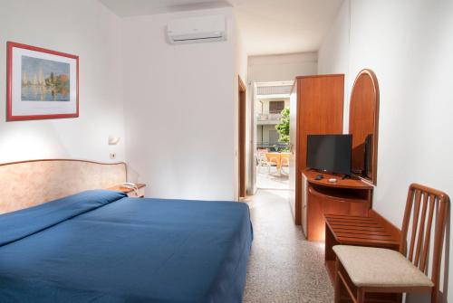 a bedroom with a bed and a desk with a tv at Hotel Holiday in Misano Adriatico