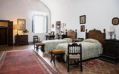 sypialnia z 2 łóżkami, stołem i krzesłami w obiekcie Castello Malaspina di Fosdinovo w mieście Fosdinovo