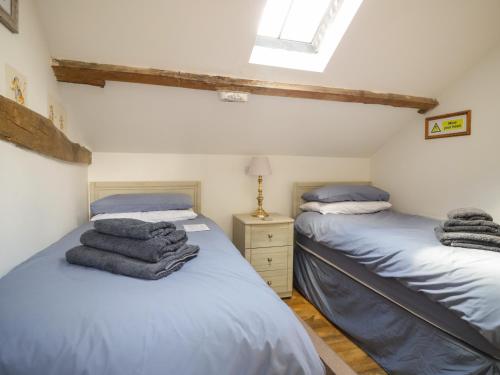 two twin beds in a room with a window at Mousehole Cottage in Carlisle
