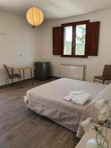a bedroom with a large bed and a table at Sonnellino in Maremma in Massa Marittima