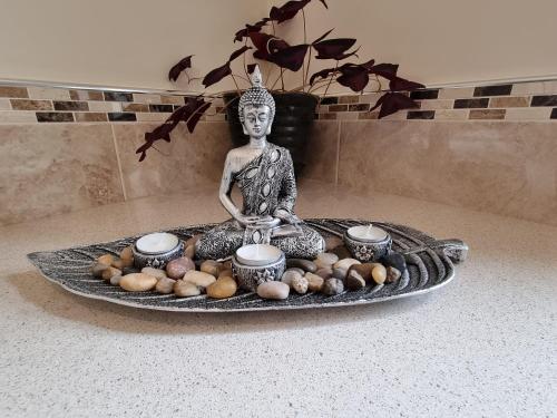 a statue of a buddha sitting on a table with vegetables at Rinroe View in the Barony of Erris in Ballina