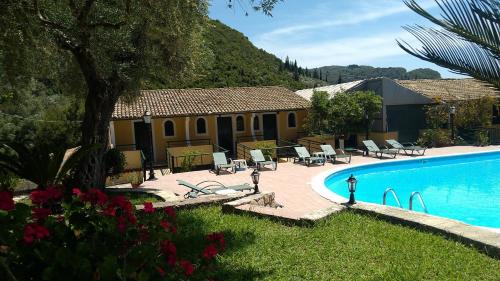 a resort with a pool and chairs and a building at Aphrodite Studios & Pool in Paleokastritsa