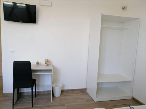 Habitación con escritorio, silla y TV. en I TRE CUORI, en Taormina