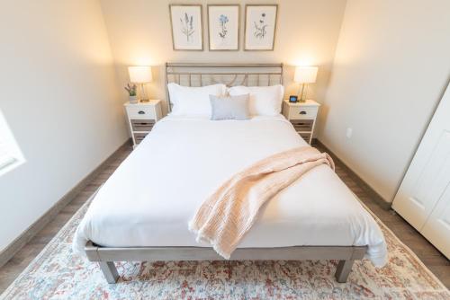 a bedroom with a large bed with white sheets and pillows at Susitna Suites in Wasilla