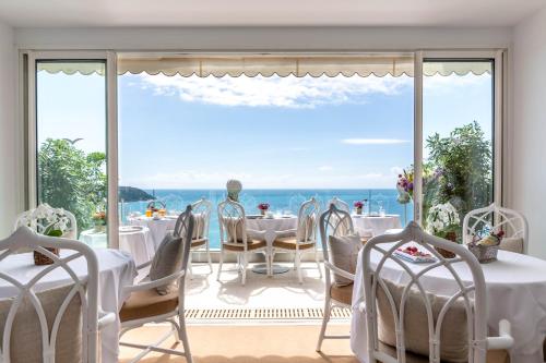 - une salle à manger avec vue sur l'océan dans l'établissement Hôtel Le Roquebrune, à Roquebrune-Cap-Martin