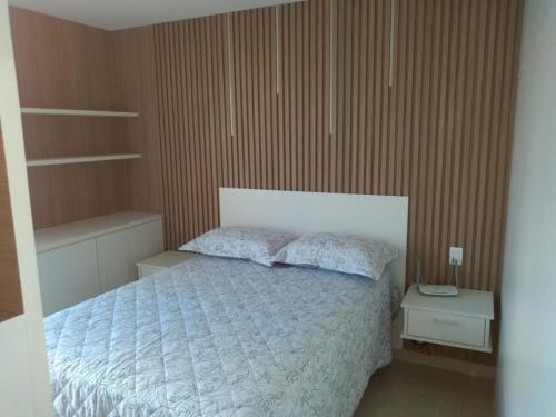 a bedroom with a bed with a white comforter at Flat Super Aconchegante no DNA - Proximo ao Vaca Brava in Goiânia